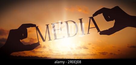 Media - human hands holding black silhouette word Stock Photo - Alamy
