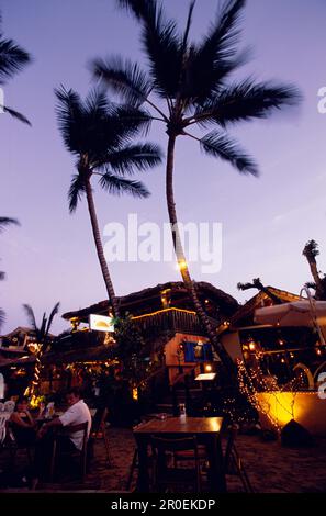 Restaurant in the evening, on the beach of Cabarete, People are sitting on plastic chairs, Dominican Republic Stock Photo