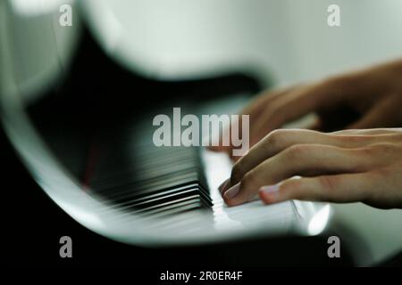 Man playing piano, close-up hands, Germany Stock Photo