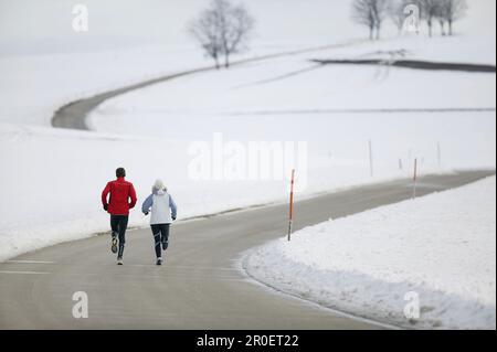 Young couple running on country road Stock Photo