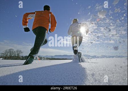 Young couple walking through powder snow Stock Photo