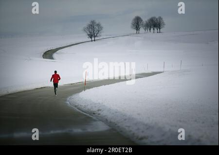Young man running on country road Stock Photo