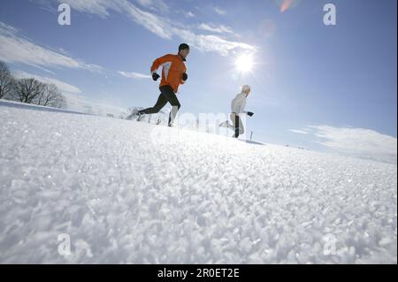 Young couple running through deep snow Stock Photo