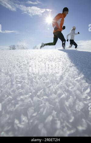Young couple running through deep snow Stock Photo