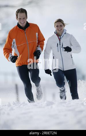 Young couple running on snow Stock Photo