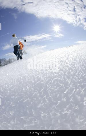 Young couple running through deep snow Stock Photo