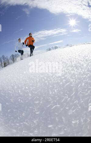 Young couple running through deep snow Stock Photo