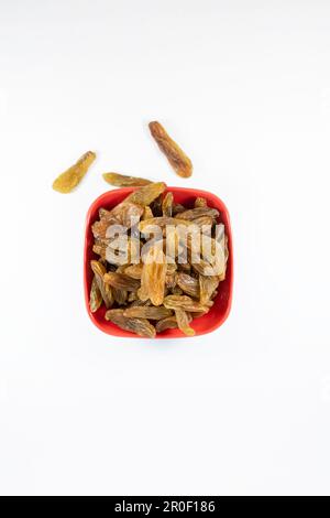 A close-up of a bowl filled with dried raisins against a white background Stock Photo