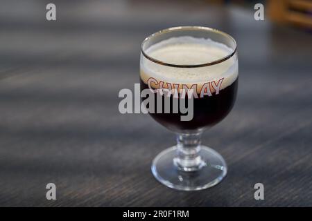 Glass of Chimay Blue Trappist beer with a logo of Chimay Brewery Stock Photo