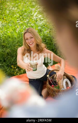 Young woman holding glass, man holding water bottle Stock Photo