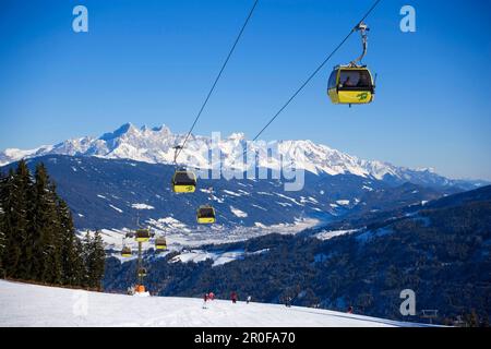 Cabin cable car and skiers on slope Dachstein Mountains at horizon, Flachau, Salzburger Land, Austria Stock Photo