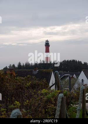 A beautiful landscape featuring the historic Hornum lighthouse on a lush green hill Stock Photo