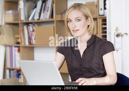 Young woman working on a computer, notebook, Munich, Bavaria, Germany Stock Photo