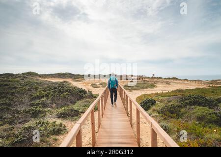 Young and adventurous Vagabond wandering the Portuguese countryside on the Fisherman Trail enjoys the views of the Atlantic Ocean at a lookout point. Stock Photo