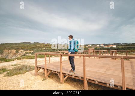 Young and adventurous Vagabond wandering the Portuguese countryside on the Fisherman Trail enjoys the views of the Atlantic Ocean at a lookout point. Stock Photo