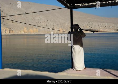 Full length shot of a fisherman on a chair with an old boot on the fishing  rod isolated on white background Stock Photo - Alamy