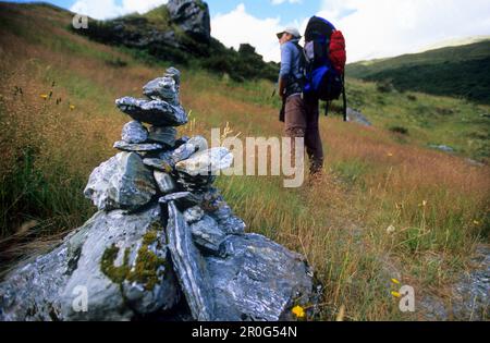 Trekker and cairn on the Rees Dart Track at upper Dart Valley, Mt. Aspiring National Park, South Island, New Zealand, Oceania Stock Photo
