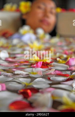 A woman bathing in a bath tub filled with blossoms, Spa of the Chedi Club, GHM Hotel, Ubud, Indonesia, Asia Stock Photo
