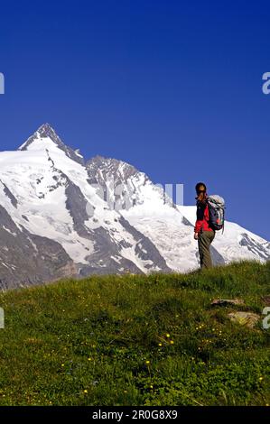 Woman with rucksack on a meadow in front of the Grossglockner, Hohe Tauern, Austria, Europe Stock Photo