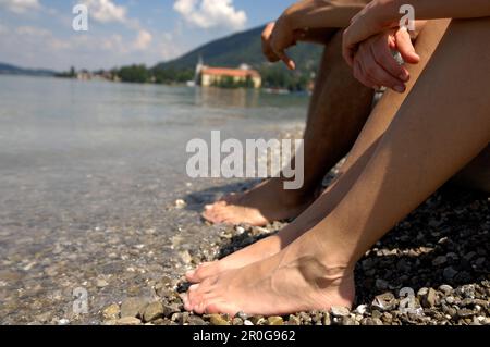 Two people bathing their feet in the water of a lake, Lake Tegernsee, Upper Bavaria, Bavaria, Germany Stock Photo
