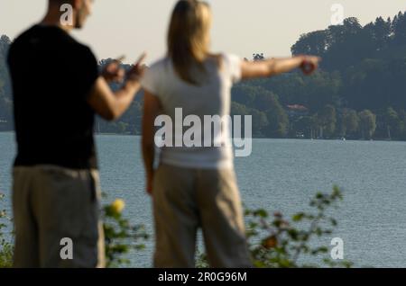 Couple at Lake Tegernsee, Woman is pointing her finger towards something, Lake Tegernsee, Upper Bavaria, Bavaria, Germany Stock Photo