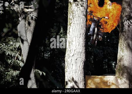 BMX bike rider jumping through fireball, Mindelheim, Bavaria, Germany Stock Photo