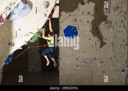 Man climbing on a overhang inside a climbing gym, Linz, Upper Austria, Austria Stock Photo