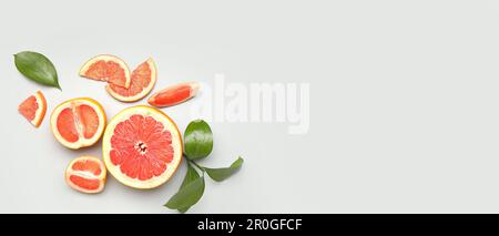Ripe cut grapefruits on light background with space for text Stock Photo