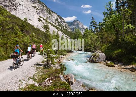 Families cycling along Isar Cycle Route, Hinterau Valley, Karwendel range, Tyrol, Austria Stock Photo