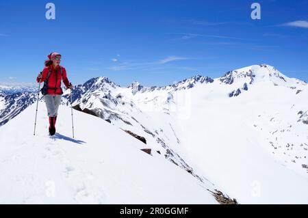 Woman ascending mountain Im Hinteren Eis, Weisskugel in background, Schnals valley, Oetztal Alps, Vinschgau, Trentino-Alto Adige/Südtirol, Italy Stock Photo