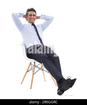 He enjoys his career. A handsome young businessman relaxing in a chair with his hands behind his head. Stock Photo