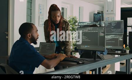 Software engineers brainstorming ideas to develop it code on computer, working on new user interface in agency office. Team of programmers collaborating on app development group project. Stock Photo