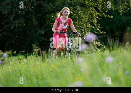 Woman cycling through Rosenstein Park, bike tour, e-bike, Rosenstein Park, Stuttgart, Baden-Wurttemberg, Germany Stock Photo