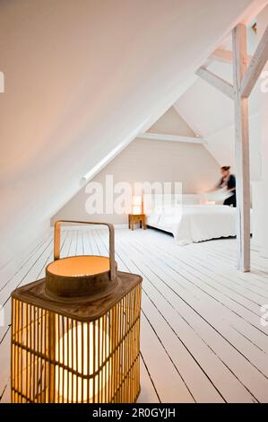 Woman making the bed, Bedroom furnished in country style, Hamburg, Germany Stock Photo