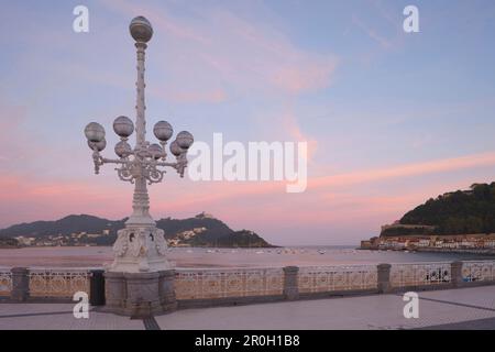 Street lamp at the seaside promenade at dusk, Playa de la Concha, Bahia de la Concha, San Sebastian, Donostia, Camino de la Costa, Camino del Norte, c Stock Photo