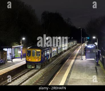 Northern Rail class 769 bi mode flex train 769448 calling at Hindley railway station at night while running on diesel Stock Photo