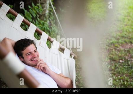 Man lying in a hammock, Kaltern, Bozen, Trentino-Alto Adige/Suedtirol, Italy Stock Photo
