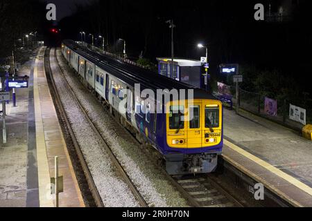 Northern Rail class 769 bi mode flex train 769448 calling at Hindley railway station at night while running on diesel Stock Photo