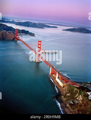 USA, San Francisco, an aerial view of a container ship passing under the Golden Gate Bridge, a view towards the Marin Headlands, Tiburon and Angel Isl Stock Photo