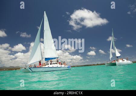 MAURITIUS, Trou D'eau Deuce, tourists sail in the Indian Ocean off the East coast of Mauritius with the 4 Sisters Mountains in the background Stock Photo