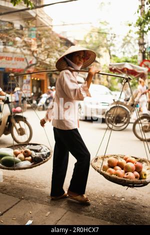 VIETNAM, Hanoi, a woman sells fruit on the street in front of Cafe Nang in the Old quarter Stock Photo