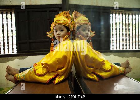 VIETNAM, Hue, Tu Duc Tomb, a young dancer is dressed in traditional Vietnamese costume and waits to perform with his mother Stock Photo