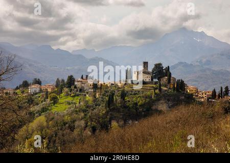Small village under Alps mountains. Dramatic clouds over Alpi Apuane mountains and Barga town in Italy, Europe Stock Photo
