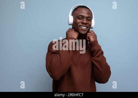 cool energetic dark-skinned american man with modern wireless headphones on the background with copy space Stock Photo