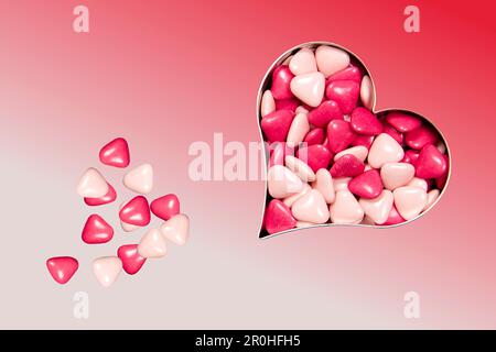 Rosa heart shaped bonbons in a heart form box Stock Photo