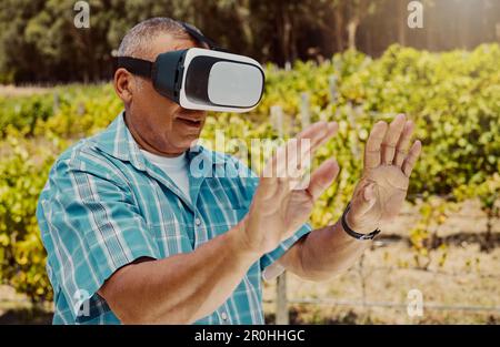 One senior mixed race farmer using a virtual reality headset through metaverse. Hispanic elderly man touching augmented reality in multiverse. Old man Stock Photo