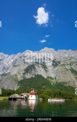 Excursion boat in front of baroque style pilgrimage church St Bartholomae, Watzmann east wall in the background, Koenigssee, Berchtesgaden region, Ber Stock Photo