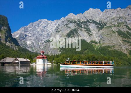 Excursion boat in front of baroque style pilgrimage church St Bartholomae, Watzmann east wall in the background, Koenigssee, Berchtesgaden region, Ber Stock Photo