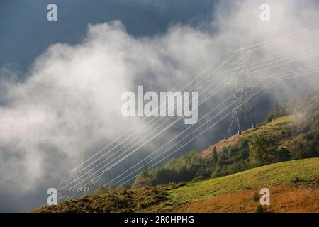 Electricity pylons in fog, Kaprun, Salzburg, Austria Stock Photo