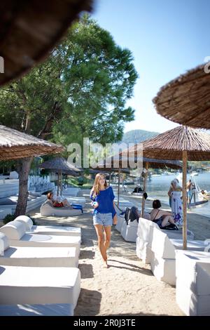 Woman walking along a hotel beach, Chalkidiki, Greece, Model Release for woman in front Stock Photo